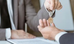 Real estate professionals and clients discussing home purchases, insurance or real estate loans. Home sales agents sit at the office with new homebuyers in the office