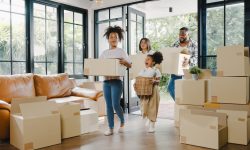 Family with one woman, a man and two young kids moving into a new house with all their cartons in the living area